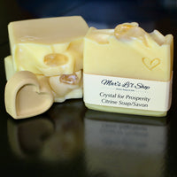 Some may believe that crystals possess certain health benefits for the body and mind. This soap bar features a lovely Citrine Crystal and is infused with Tangerine essential oil. Also known as the success stone, Citrine is thought to stimulate enthusiasm, creativity, and focus. Whether a crystal instantly resonates with you or you feel a mystical attraction to it, trust your subconscious to lead you to the right stone.  Remove the crystal, rinse it off and enjoy! 